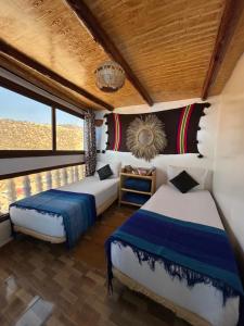 une chambre avec deux lits et une fenêtre dans l'établissement Ami D'or Hostel, à Taghazout