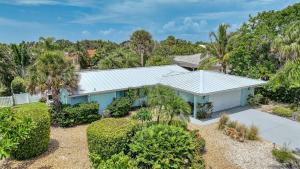 a blue house with trees and bushes at La Contento Casa - 5560 in Siesta Key