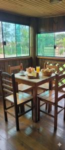 - une table et des chaises avec un bol de nourriture dans l'établissement Pousada Ilha Sul, à Cananéia