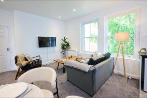a living room with a couch and a table at 1A Central Bedford Apartment in Bedford