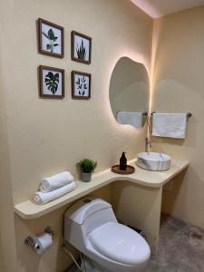 a bathroom with a white toilet and a sink at Cabañas Campestres, habitacion Villavicencio in Villavicencio