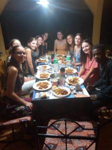 un grupo de personas sentadas alrededor de una mesa con comida en Lepianodekory, en Poutou