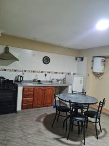 a kitchen with a table and some chairs and a counter at Hospedaje Temporal del Alto in San Salvador de Jujuy