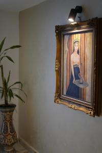a painting of a man on a wall next to a plant at Le 146 - Art of Living in Rabat +25 photos