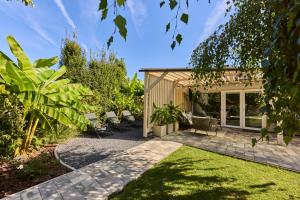d'un jardin avec une terrasse meublée de chaises et de plantes. dans l'établissement Relax Balaton, à Balatonőszöd