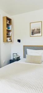 - une chambre avec un grand lit blanc et une étagère dans l'établissement Relax Balaton, à Balatonőszöd