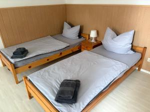 2 Einzelbetten in einem kleinen Zimmer mit einer Lampe in der Unterkunft Ferienwohnung Seeglück - 4 Schlaf- & 4 Badezimmer in Tauche