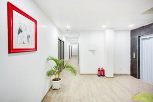 a hallway with a potted plant and a picture on the wall at Super Townhouse Townhouse Atal Chowk Indirapuram Ghaziabad in Ghaziabad