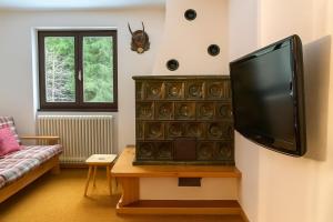 a living room with a flat screen tv on a wall at Appartamento Magico Abete in Bellamonte +5 photos