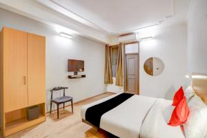 a hotel room with a bed and a chair at Super Capital O Jp Tower in New Delhi