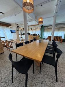 a large wooden table and chairs in a room at Hostel 360 Patagonia in El Bolsón