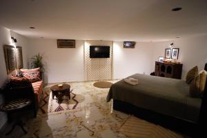 a bedroom with a bed and a tv and a chair at Le Loft Bleu in Rabat +18 photos