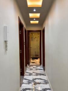 - un couloir avec du carrelage dans un bâtiment dans l'établissement الفريده شقة فندقية, à Mudīrīyah