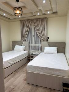 une chambre avec deux lits et une fenêtre dans l'établissement الفريده شقة فندقية, à Mudīrīyah