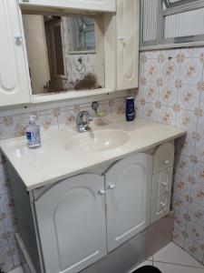 a bathroom with a white sink and a mirror at Aunt A CASA DOS SONHOS DA TIA LETÍCIA in Miguel Pereira