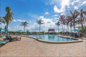 a swimming pool at a resort with palm trees at Beachfront 2BR at The Tides | EPIC Stay in Hollywood