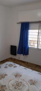 a room with a blue window and a rug at Rentals Temp - Deptos in San Clemente del Tuyú