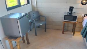 a room with a chair and a table and a microwave at Selva y Mar in Holbox Island