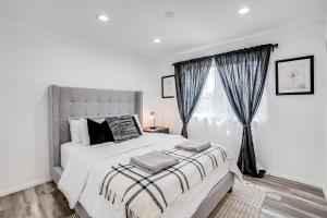 a white bedroom with a large bed and a window at Vacation House with Pool in Garnsey +25 photos