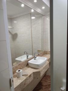 un baño con lavabo y espejo en Casas para Temporada RS, en Praia Grande