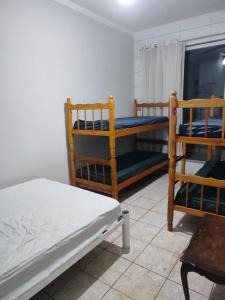 1 dormitorio con 2 literas y 2 sillas en Casas para Temporada RS, en Praia Grande
