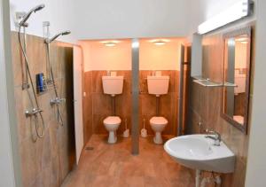 a bathroom with two toilets and a sink and a shower at Apartment Bremerhaven in Bremerhaven