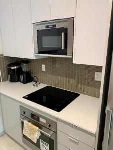 a kitchen with a counter top with a microwave at Luxury Suites In Good Location in Richmond Hill