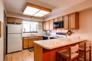 a kitchen with wooden cabinets and a white refrigerator at Winterpoint 42 by Ski Country Resorts in Breckenridge