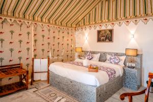a bedroom with a bed in a room with wallpaper at Grand Inara Camp in Jaisalmer +38 photos
