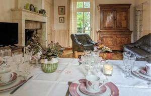 Un comedor con una mesa con platos y vasos. en Stunning Home In Ceaux-En-Loudun, en Ceaux-en-Loudun