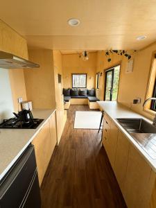 a kitchen with a counter top and a living room at Hahei Tiny Home - Outdoor Bath in Hahei