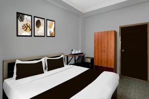 a bedroom with a large bed and a wooden cabinet at Hotel O Shamshabad Station Formerly Grand Vista Hotel in Shamshabad