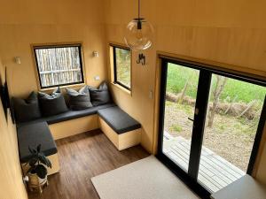 a living room with a couch in a tiny house at Hahei Tiny Home - Outdoor Bath in Hahei +9 photos