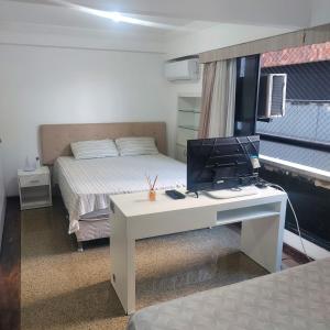 福塔莱萨Residence Scala的一间卧室配有一张桌子,里面装有电脑