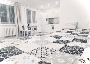 Un dormitorio con una cama con edredón blanco y negro. en M&M Apartment I near Panevezys, en Velžys
