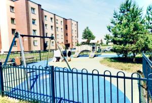 un parque infantil frente a un edificio en M&M Apartment I near Panevezys, en Velžys