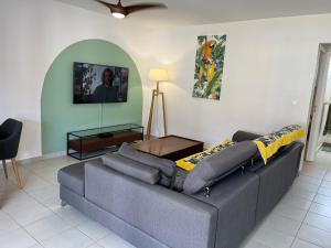 a living room with a couch and a table at Fleur de Paradis in Saint-François