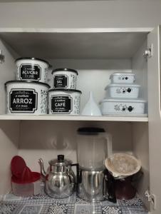 un estante de cocina lleno de ollas y sartenes en Espaço Ideal Apartamento 2 Quartos, en Cascavel