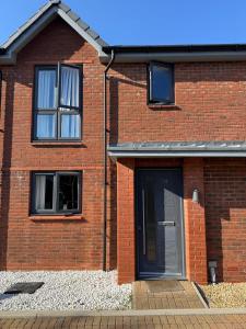 a brick house with a door and two windows at 14 Lumb close in Swindon