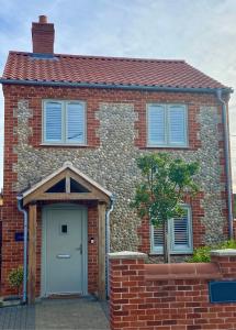 a red brick house with a white door at Boutique Burnham Market Cottage in Burnham Market