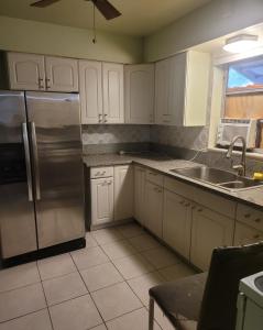 a kitchen with white cabinets and a stainless steel refrigerator at PalmBeachLake&PoolFrom69dollarsForPersonDayly 