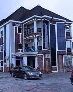 a black car parked in front of a building at Uptown Life Hotel and Suites in Warri