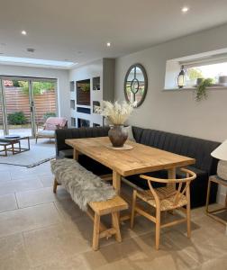 a living room with a wooden table and chairs at Boutique Burnham Market Cottage in Burnham Market