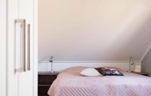 Un dormitorio con una cama con una almohada encima. en Nice Home In Makkum With Lake View, en Holle Poarte