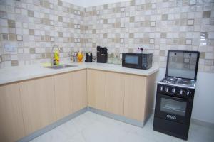 a small kitchen with a stove and a microwave at Havah Zanzibar Home in Mwanakwerekwe +15 photos