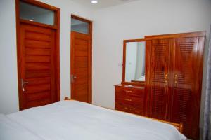 a bedroom with a bed and a dresser and a mirror at Havah Zanzibar Home in Mwanakwerekwe