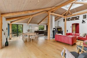 a living room with a red couch and a table at Scenic 2025 Summer House With Sea View in Dokkedal +18 photos