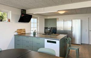 a kitchen with a refrigerator and a table with chairs at Cozy Home In Haderslev With Wifi in Haderslev