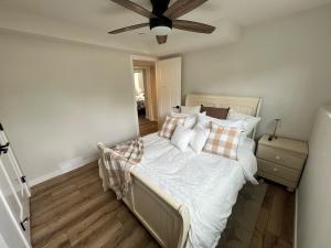 a bed in a bedroom with a ceiling fan at The West Wind Retreat in Lethbridge