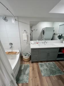 a bathroom with a tub and a sink and a bath tub at The West Wind Retreat in Lethbridge